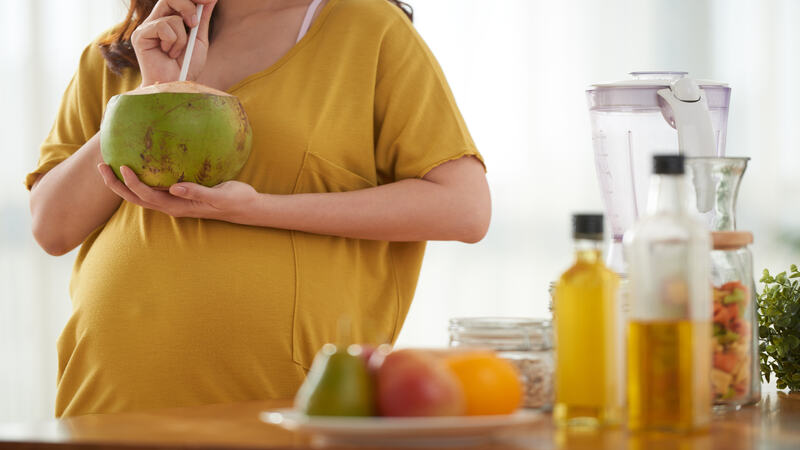 pregnant woman drinking coconut water