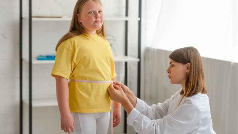 Doctor checking obese child weight