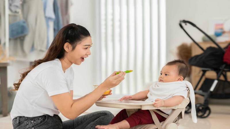 mom-feeding-puree-to-baby-in-chair