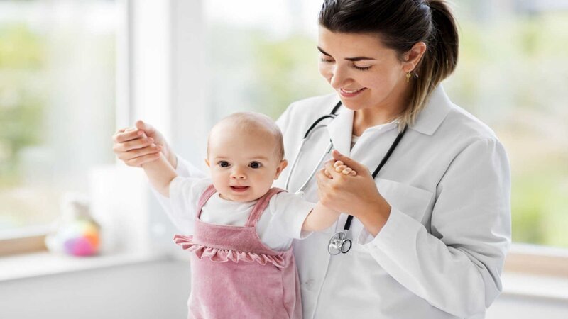 doctor-holding-baby-to-stand