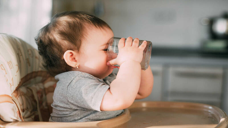 baby-holding-open-cup-and-drinking