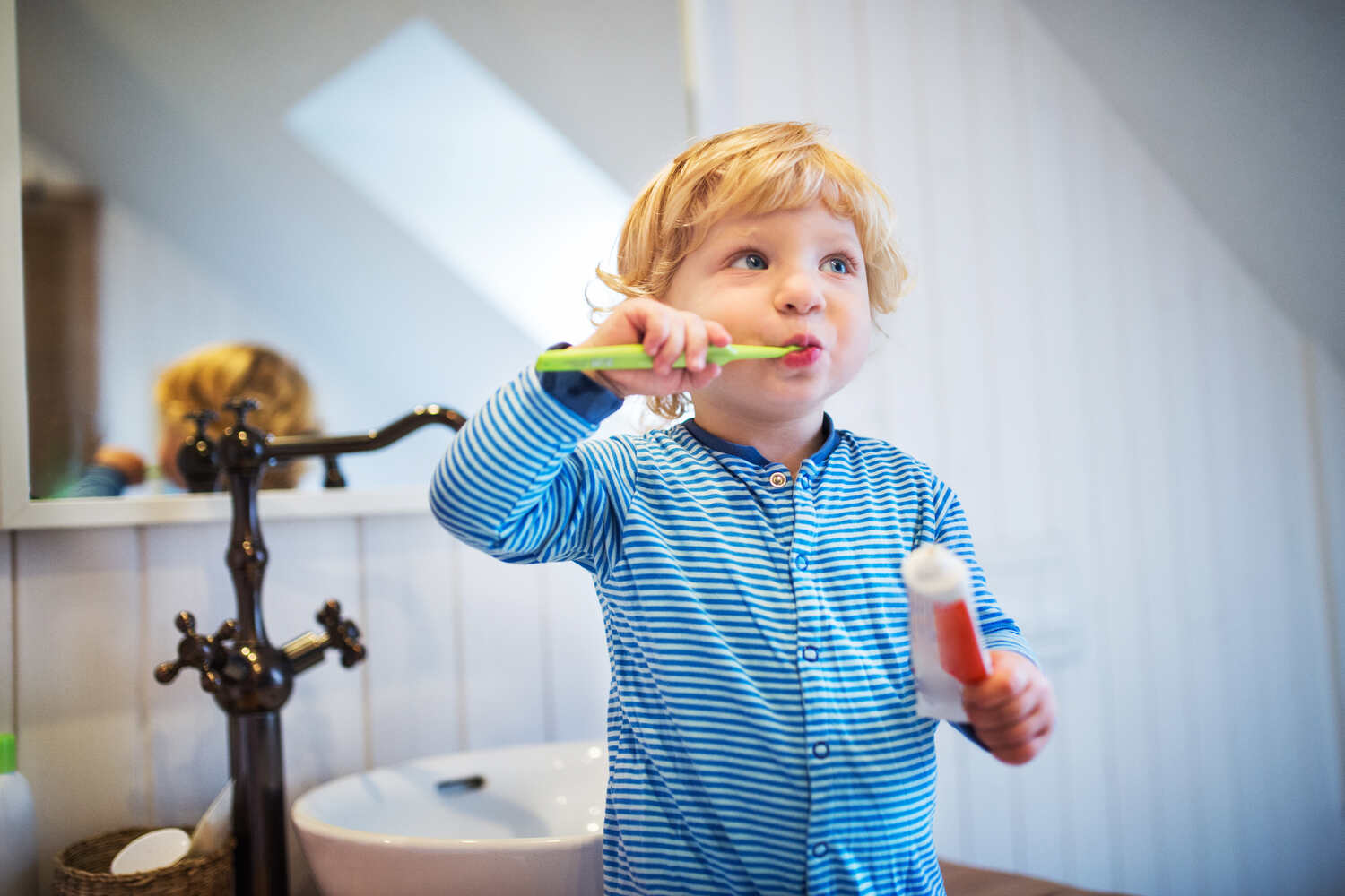 A toddler boy brushing his teeth