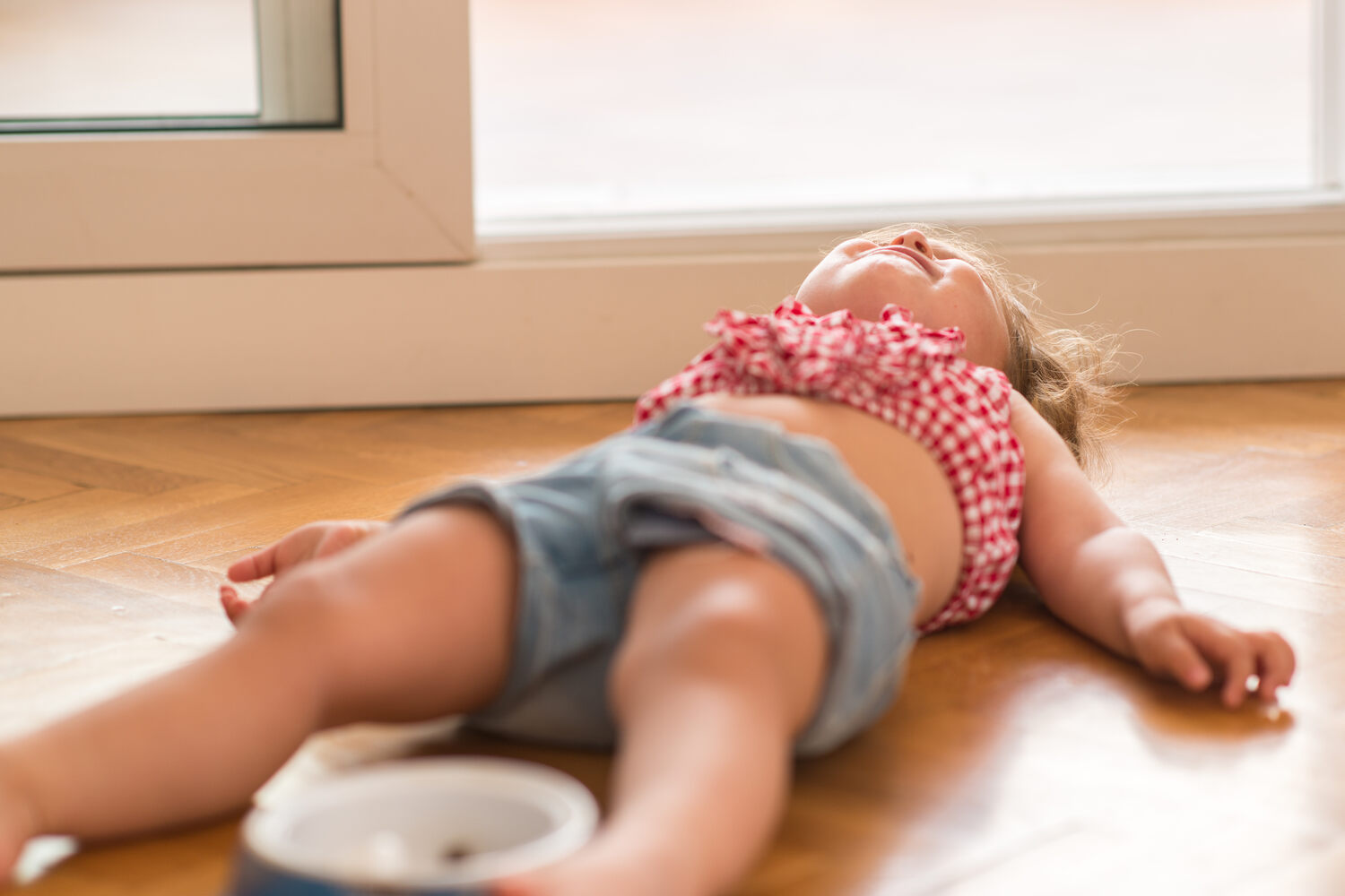 A toddler girl lying on floor