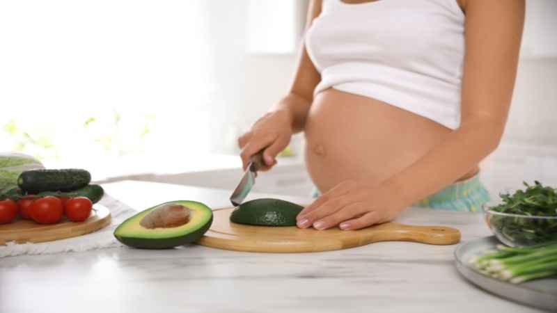 pregnant women cutting Avocado