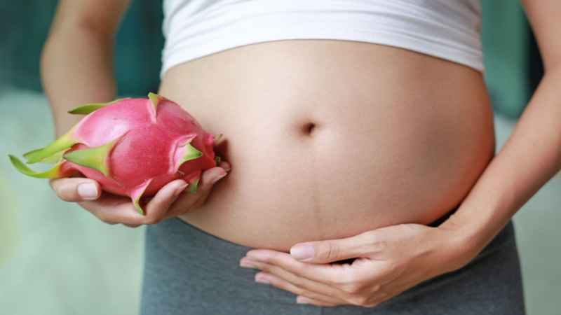 pregnant women holding dragon fruit