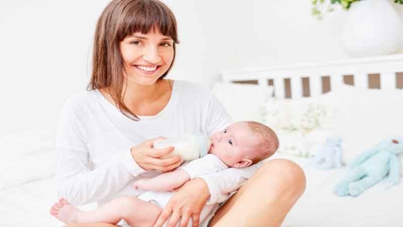 mother gives baby powdered milk